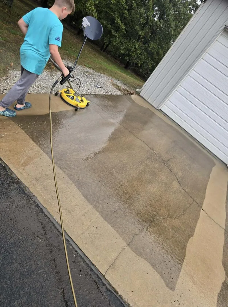 Surface cleaner stripping grime off a concrete driveway