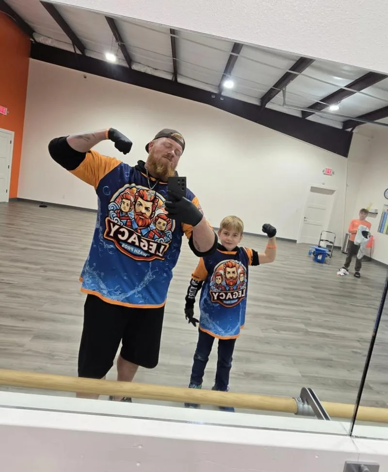 Ryan and his son flexing in matching Legacy Wash Pros jerseys