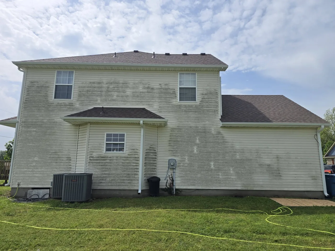 Two-story vinyl siding streaked with mildew before washing